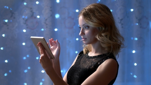 Beautiful Woman on a Party Is Using a Touch Pad 