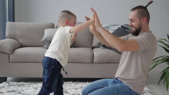 Happy Father Teaches his little Son Boxing