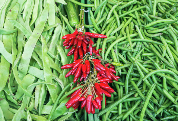 Fresh string beans and red chili peppers on a market stall