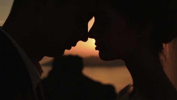 Happy Married Couple Bowed To Each Other  On Church Roof At Sunset Sky Background