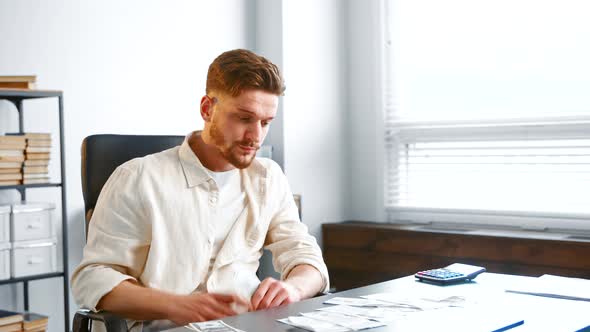 Company director in yellow shirt takes dollar banknotes alt