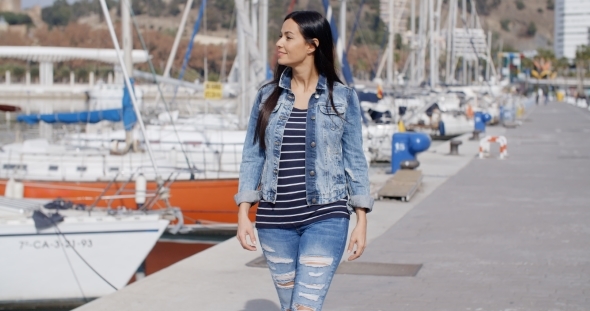 Pretty Woman Strolling On a Waterfront Promenade alt