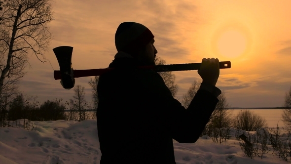 Silhouette Lumberjack Standing With His Ax In Sunset Time