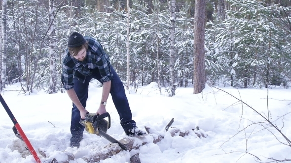 Lumberjack Chainsaw Manual Sawing Wood In The Winter Snowy Forest