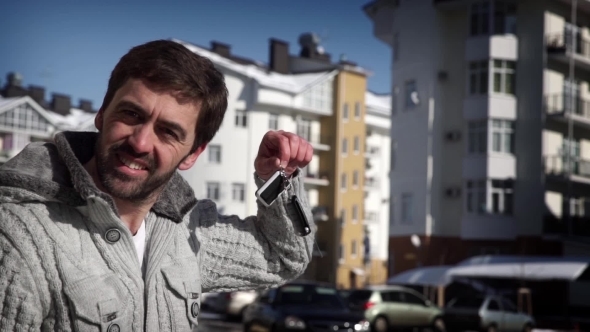 Man Holding Keys To New Car Auto And Smiling At Camera