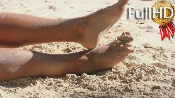 Female Feet in Sand on The Beach