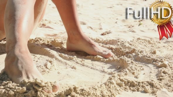 Female Legs Play With Sand on The Beach