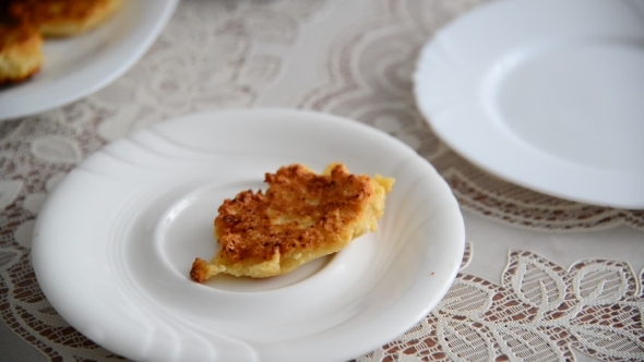 Housewife Puts Cheese Pancakes On  Plate And Pours Raspberry Jam