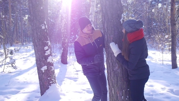 A Young And Loving Couple Is Playing Near The Tree In The Winter Forest