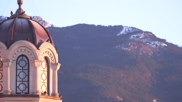 The Building is Lit By the Rising Sun in the Background of the Mountains