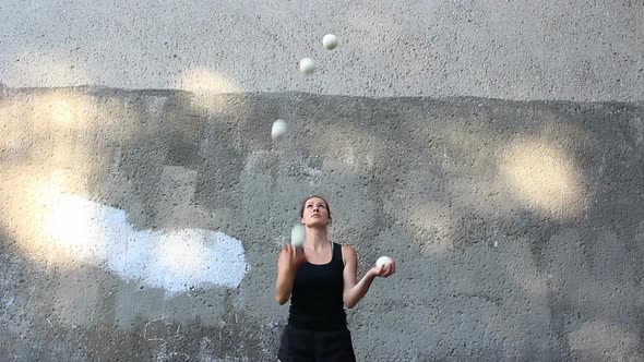 A Professional Juggler Juggles with White Balls