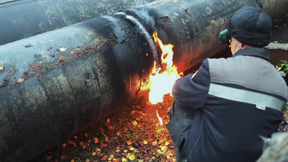 The Welder Cuts Large Metal Pipes with Ocetylene Welding