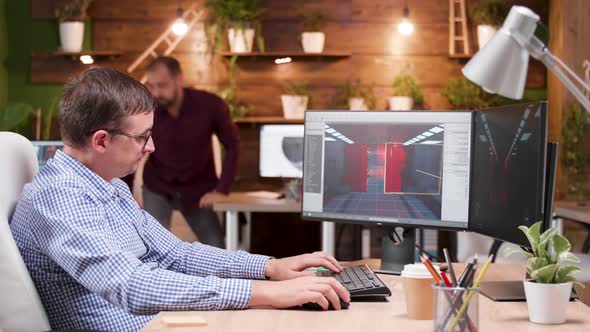 Graphic Designer in Gaming Industry Talking Detail with His Assitant alt