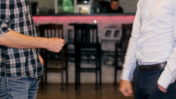 Two Men In Jeans Stand Opposite Each Other alt