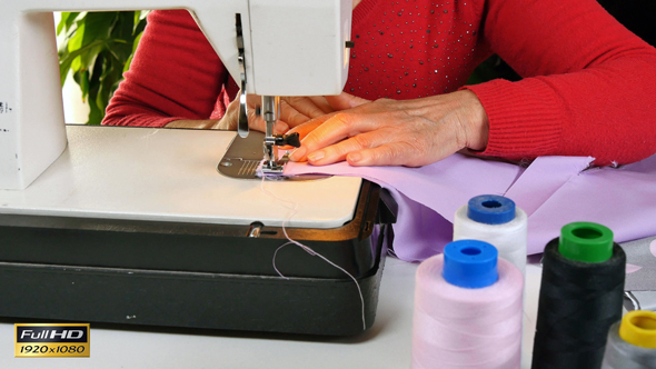 Tailor Sewing Clothes with her Sewing Machine alt