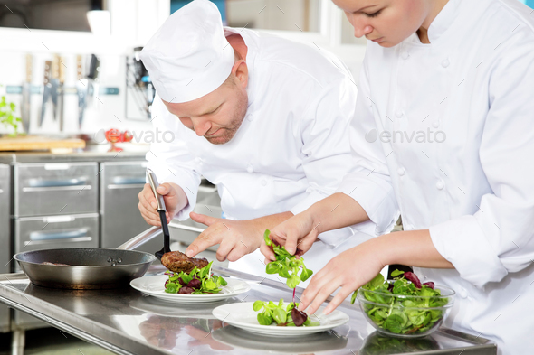 Two chefs prepares steak dish at gourmet restaurant - Stock Photo - Images