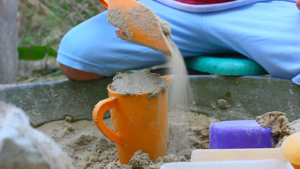 Child Playing With Plastic Toys In Sandbox