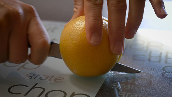 Cutting an Orange on a Chopping Board