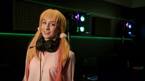 Medium Closeup Portrait of Cute Competitive Caucasian Gamer Girl in Headset Looking at Camera alt