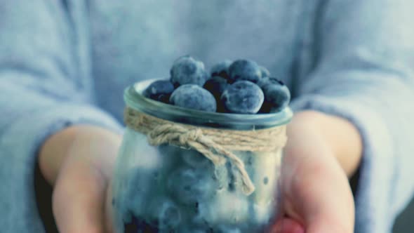 Woman Holding Bowl with Frozen Blueberry Fruits alt
