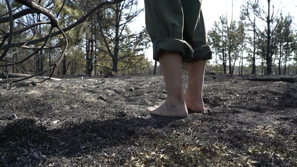 barefoot feet walking by burned forest