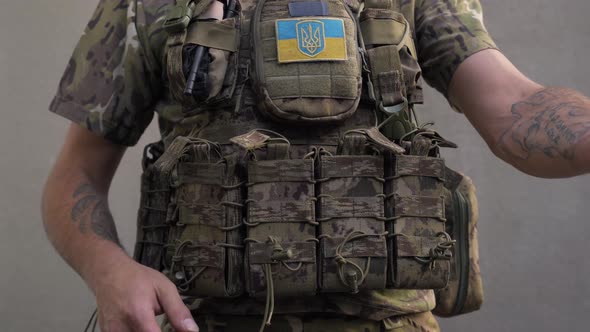 Ukrainian Military Man in Combat Camouflage and Body Armor Puts a Magazines Clips of Ammunition to alt