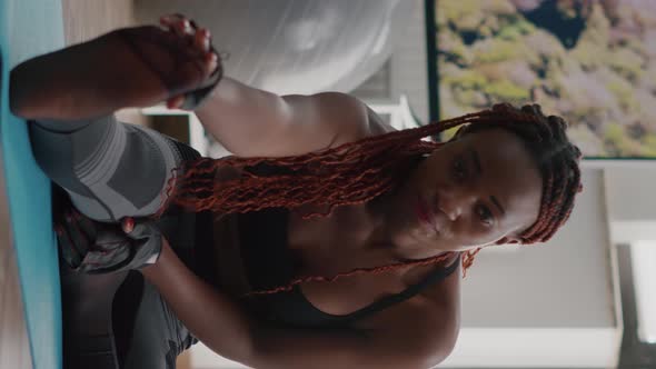 Verical Video Woman with Black Skin Doing Workout in Living Room Stretching Exercise alt