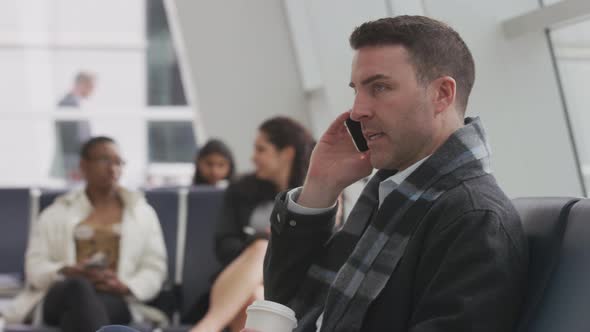 Business man talking on cell phone at airport