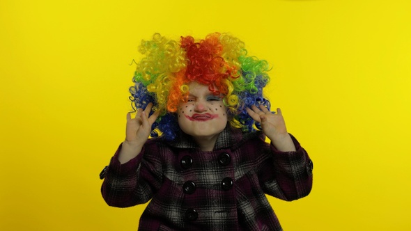 Little Child Girl Clown in Colorful Wig Making Silly Faces. Having Fun, Singing, Dancing. Halloween alt