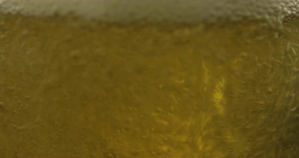 Pouring Cold Golden Light Beer Into a Glass. Craft Beer Making Bubbles and Foam alt