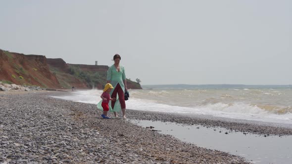 Mother and Little Cute Child are Walking on a Windy Beach Along the Black Sea Mother and 1 alt