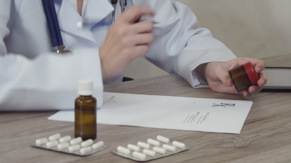 The Doctor Looks At Medicine And Writes a Prescription. alt