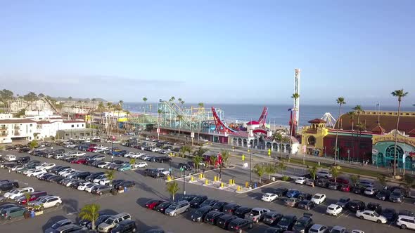 Parking area cars palms, amusement park, roller coaster. Stunning aerial view flight sinking down dr alt