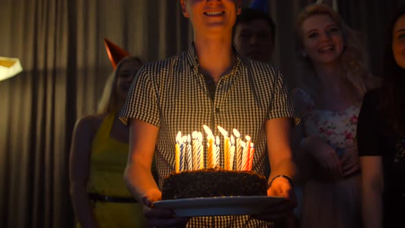 Happy Male with Friends Bringing Birthday Cake To You. alt