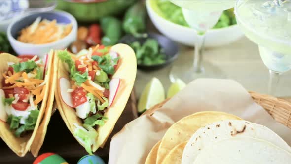 Ground beef tacos with romaine lettuce, diced tomatoes, radishes, and shredded cheddar cheese. alt