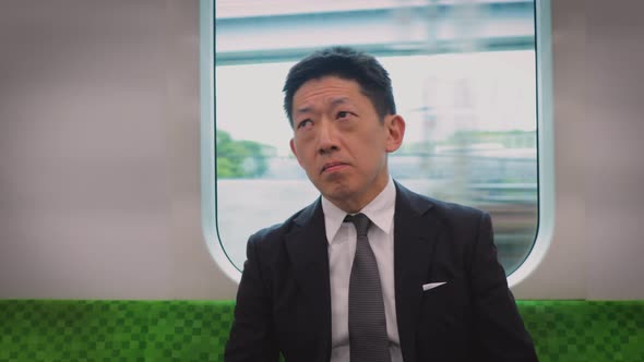 Japanese businessman rising in a train alt