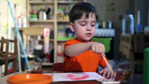 Joyful Child At The Table With a Brush