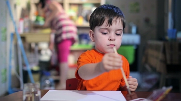  Boy At The Table Draws With a Brush