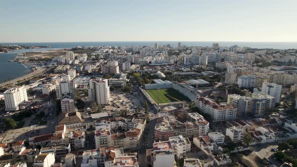 Portimão Aerial cityscape, Flying through Soccer Stadium surrounded by Residential Buildings alt
