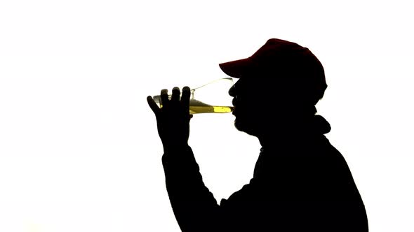 Guy Drinks a Glass of Beer. Side View. Silhouette White Background alt
