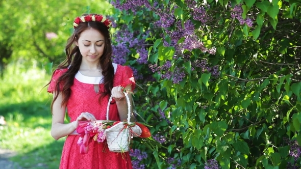 Beautiful Woman In a Red Dress With a Wreath And a Basket With Tulips