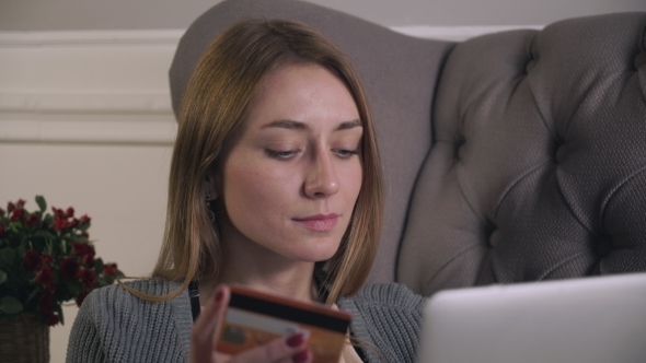 Young Girl Sitting On The Couch Purchases Via The Internet alt