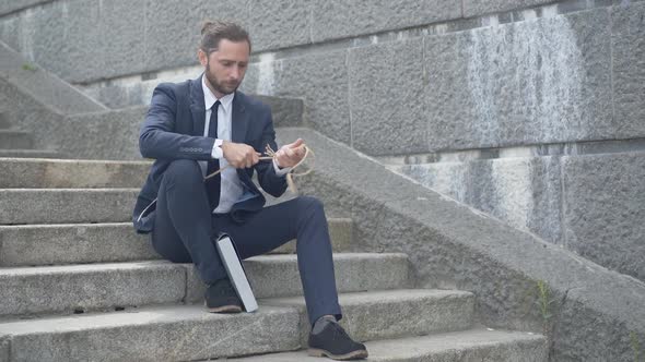 Wide Shot of Upset Frustrated Young Man Preparing Rope for Suicide. Portrait of Depressed Caucasian alt