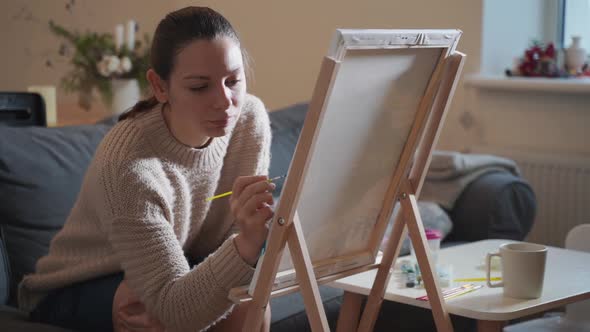 Young Millennial Woman Painting with Acrylic Paints at Home alt