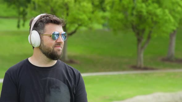 Slow Motion Smiling Handsome Guy While Listening Music in Green Park RED HELIUM alt