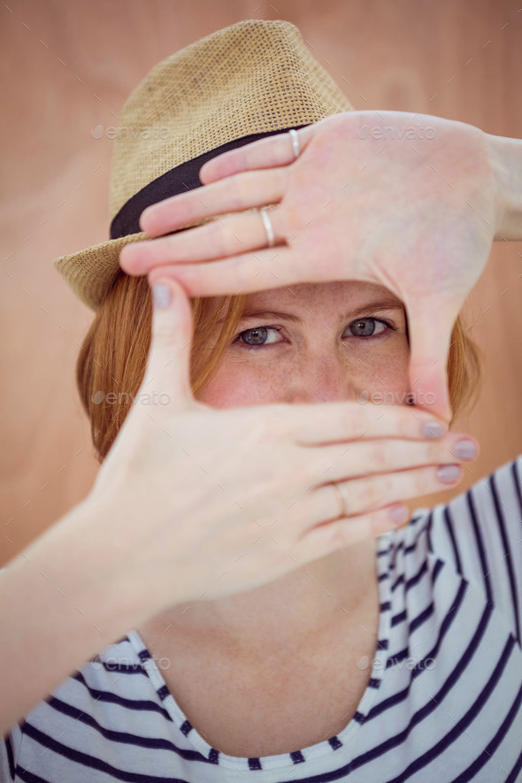 blue eyed hipster in a trilby, looking through her hands - Stock Photo - Images