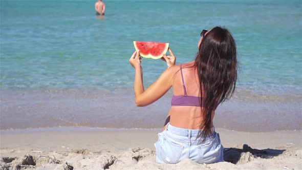 Happy Girl Having Fun on the Beach and Eating Watermelon alt