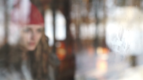 Sad Woman Looking The Rain Falling Through a Window At Home Or Hotel