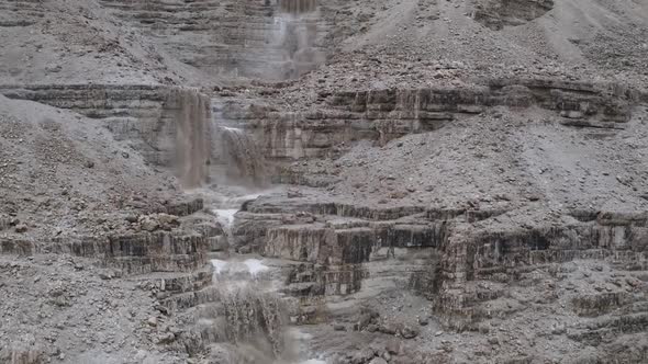 Aerial Fly Over powerful muddy waterfall after a flood in Israel Judean Desert alt