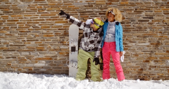 Snowboarder With Happy Friend Pointing Upwards alt